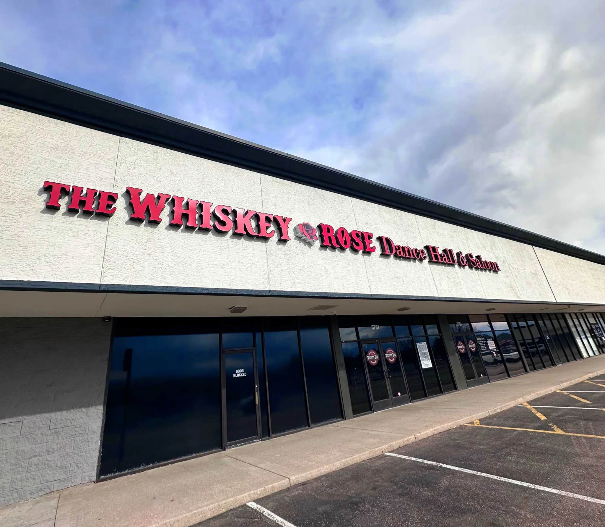 white building with red text that says the whiskey rose dance saloon
